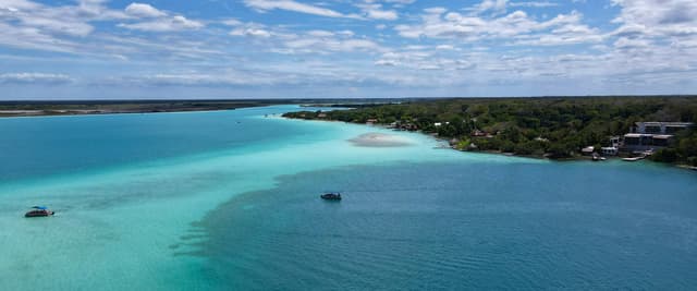 Aerial view of Bacalar lagoon with turquoise water and jungle shoreline