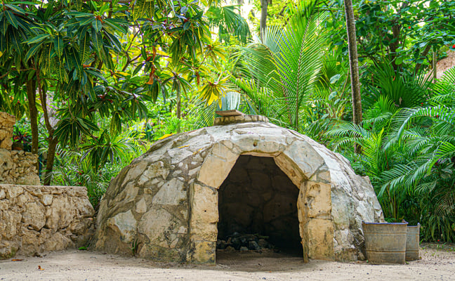 Stone dome temazcal structure in lush jungle greenery, Yucatan Mexico